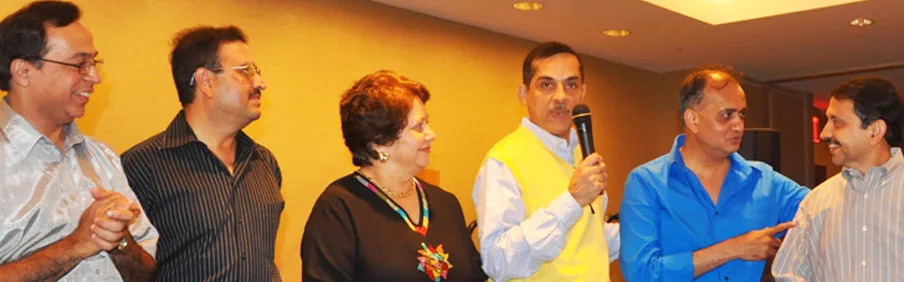 TNMC alumni sharing a toast and a microphone at a reunion